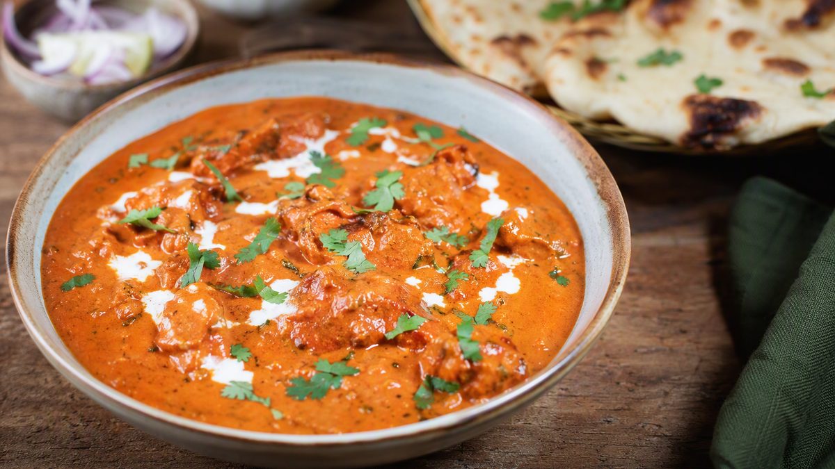 Bowl of butter chicken with naan