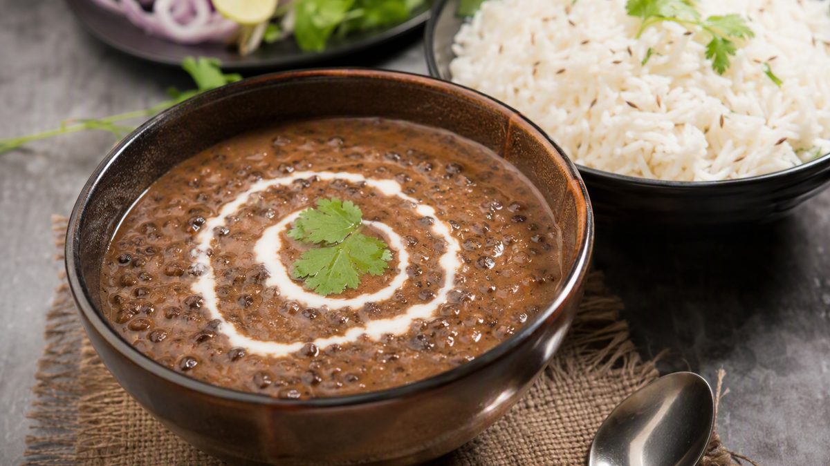 Bowl of dal makhani with cream swirl, jeera rice