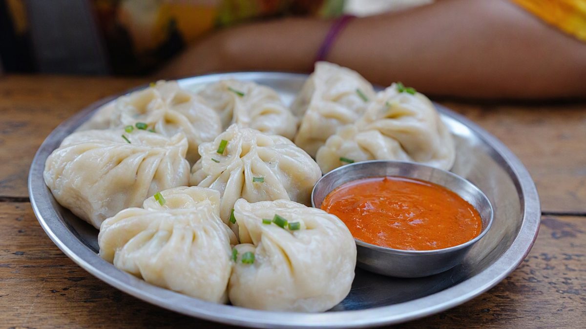 Plate of steamed momos with red chutney