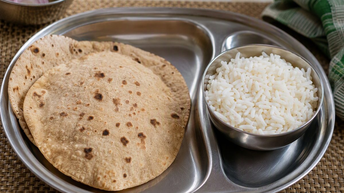 Split plate: two rotis on one side, a katori of rice on the other